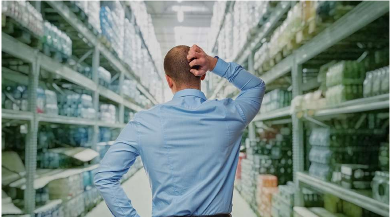 A man in a suit and tie points at a group of people, likely discussing PPC strategies at a local agency.