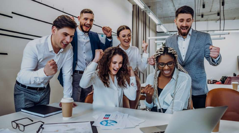 Business team joyfully celebrating in the office, marking the success of PPC ads by ScaleCode Solution.