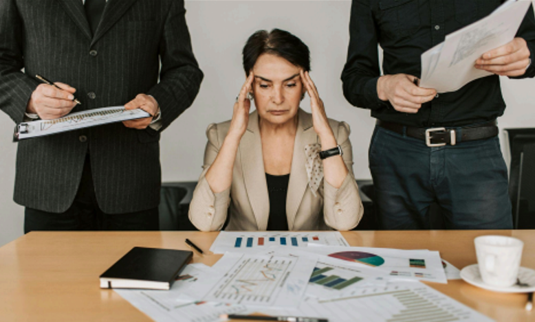 Stressed marketer looking at multiple charts and data reports, appearing confused by overwhelming analytics.