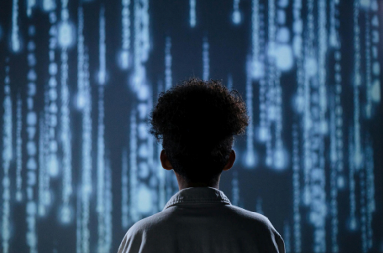 Person standing in front of a digital wall with cascading data streams, symbolizing AI and future analytics.