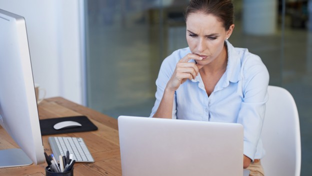 A woman seated at a desk with a laptop, exploring options for customized website design.