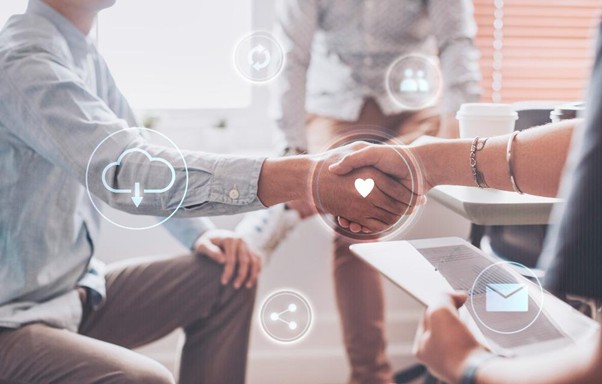 Close-up of a handshake between professionals in an office, overlaid with digital technology icons.